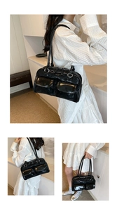Detail of black glossy shoulder bag with dual front pockets and polished finish