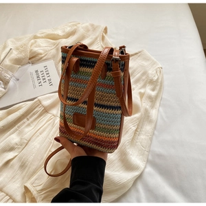 Détail d'un mini sac bohème en paille colorée avec bordure et bandoulière en similicuir