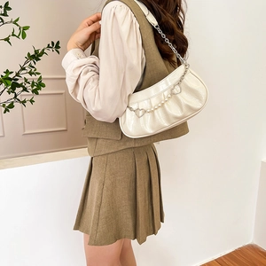 White crocodile texture underarm bag with pearl chain heart charm and green outfit