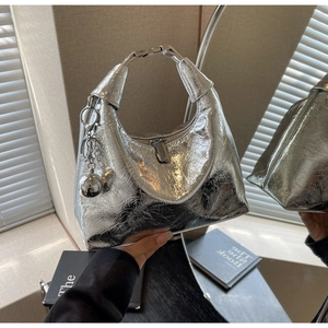 Close-up of metallic silver hobo bag with pleated texture and stylish metal hardware