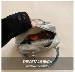 Internal capacity detail of silver metallic tote bag holding umbrella and cosmetics
