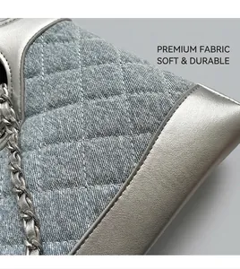 Détail du tissu denim bleu clair avec matelassage en losange et coutures en cuir argenté