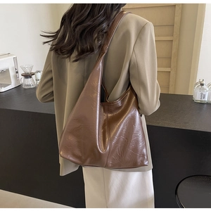 Detailed back view of a large brown vintage tote bag with soft pleated leather texture