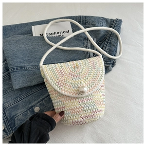 Dettaglio borsa di paglia intrecciata colorata con chiusura a perla e tracolla in corda