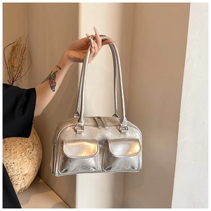 Detail of silver metallic Boston bag with two front flap pockets and oily leather texture