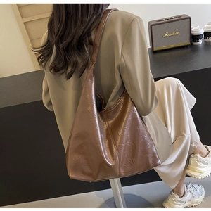 Dark brown retro tote bag featuring a glossy oil-wax wrinkled texture in a cafe setting