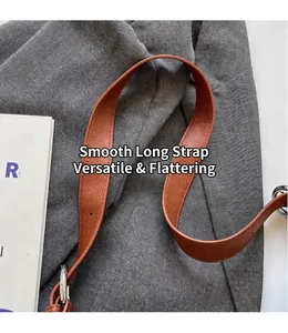 Detail of brown leather shoulder strap with silver metal ring and pebble grain texture