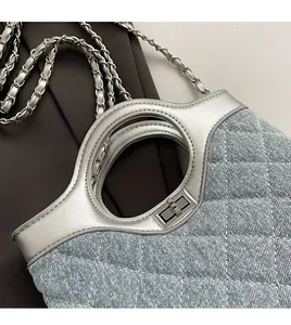 Gros plan d'un sac en denim bleu clair avec chaîne argentée et poignée ronde