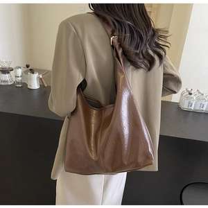 Detail of dark brown tote bag in vintage glossy leather with golden metal buckle