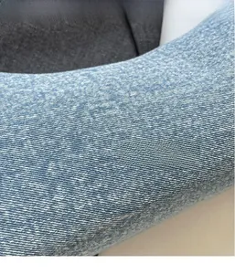 Detailed macro view of light blue denim fabric with snow-pattern twill texture for handbag