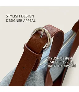 Detail of blue denim bag featuring brown leather strap and silver metal D-ring buckle