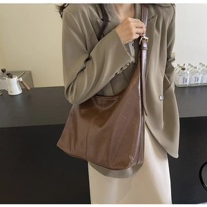 Brown textured leather tote bag showing large capacity and hobo style on model