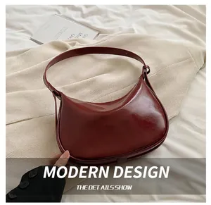 Detail der weinroten Hobo-Tasche aus Lackleder mit Reißverschluss und Riemen auf Leinen