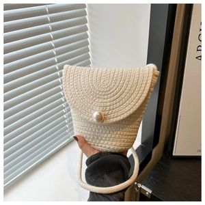 Dettaglio mini borsa in paglia intrecciata con patta e grande bottone a perla chic