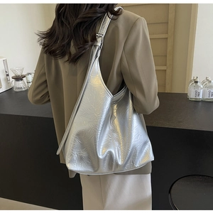 Detail of metallic silver hobo bag featuring crinkled texture and adjustable buckle strap
