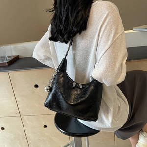 Black hobo shoulder bag in wrinkled patent leather with a silver metal ball pendant
