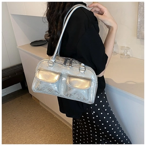 Silver oil wax leather Boston bag with double flap pockets shown on model's shoulder