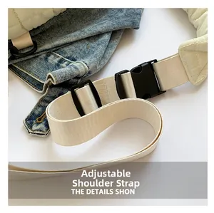 Detail of adjustable nylon strap with black plastic buckle on a cream quilted bag