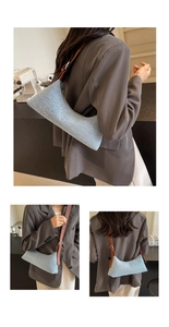 Detail of light blue textured fabric shoulder bag with brown leather strap and silver buckle