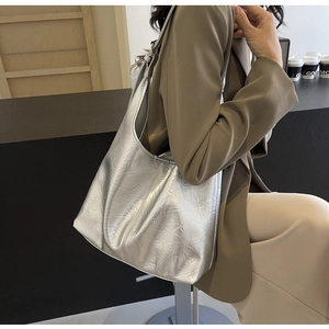 Close-up of the silver metallic wrinkled texture and hobo style shoulder strap detail