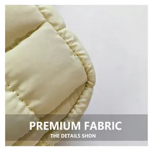 Macro view of light beige quilted nylon fabric with detailed diamond stitching and padding