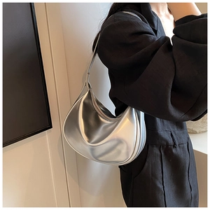 Detail der silbernen halbmondförmigen Hobo-Tasche als stilvolle Unterarm-Schultertasche