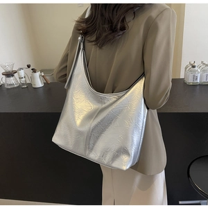 Rear view of model wearing a large silver metallic hobo bag with crinkled texture