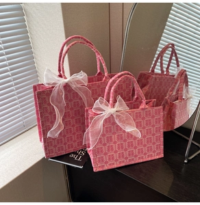 Detailliertes Set aus rosa Canvas-Taschen mit roten Xi-Zeichen und weißen Organza-Bögen