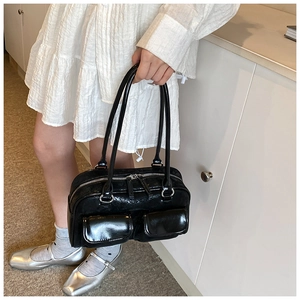 Detail of black glossy wrinkled leather Boston bag with silver zippers and front pockets