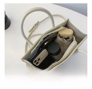 Geräumiges Innenleben der Retro-Tragetasche bietet Platz für Handy, Schirm und Kosmetik