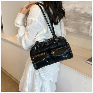Detail of black glossy patent leather shoulder bag featuring dual front utility flap pockets