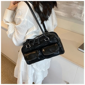 French retro black patent leather shoulder bag worn by model in minimalist interior