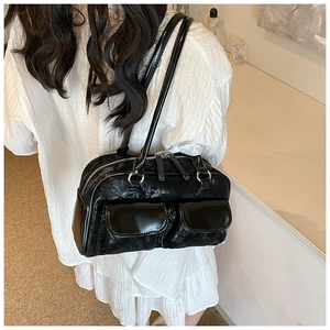 Detail view of the black wrinkled texture shoulder bag with dual flap pockets