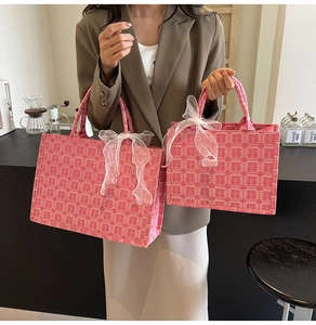 Detailansicht der rosa Stickerei-Tragetaschen mit Hochzeitsmotiven und Organzaschleifen