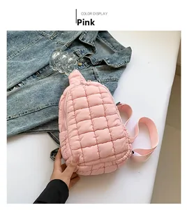 Detail of pink quilted puffer crossbody bag made from lightweight nylon fabric on desk