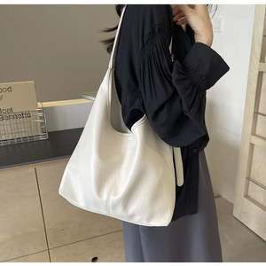 Close-up of cream white tote bag with embossed floral pattern and soft PU leather texture