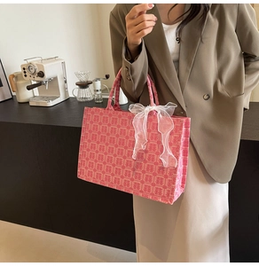 Rosa Canvas-Tasche mit roten Xi-Zeichen und einer eleganten weißen Organza-Schleife