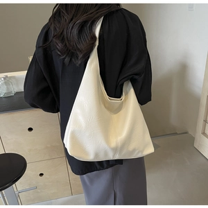 Close-up of cream pleated texture and wide strap on this oversized hobo shoulder bag