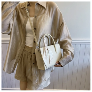 Detailansicht der cremeweißen Leder-Einkaufstasche mit elegantem Seidenschal am Griff