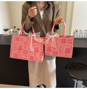 Detail rosa Braut-Taschen mit chinesischem Xi-Symbol und weißer Spitzen-Schleifen-Deko