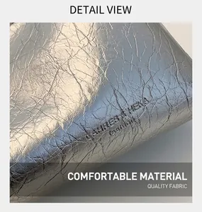 Macro view of metallic silver wrinkled texture with embossed fashion logo detail