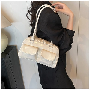 Detail of glossy beige patent leather shoulder bag with double front flap pockets