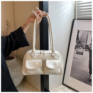 Detail of cream white underarm bag with glossy finish and two front magnetic pockets