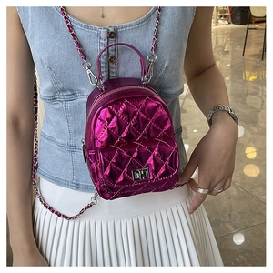 Detail of purple quilted mini backpack featuring chain straps and a metal twist-lock
