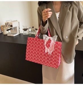 Detail der roten Hochzeitstasche mit Xi-Stickerei und großer weißer Spitzenschleife
