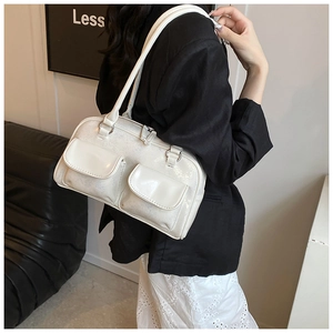 Detail of white glossy Boston bag with silver zippers and double front flap pockets