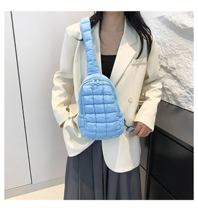 Close-up of a light blue quilted crossbody bag featuring soft nylon cloud-style stitching