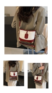 Detail view of contrast color bucket bag featuring metal corner guards and chain strap