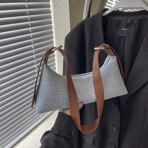 Retro denim underarm bag with brown leather straps and silver hardware for casual style