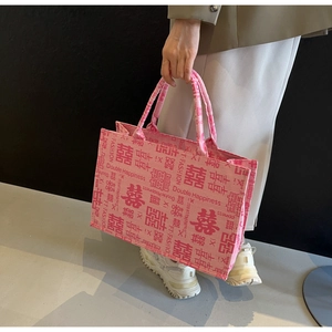 Detail der Stickerei mit chinesischem Doppelglück-Motiv auf einer rosa Canvas-Tasche